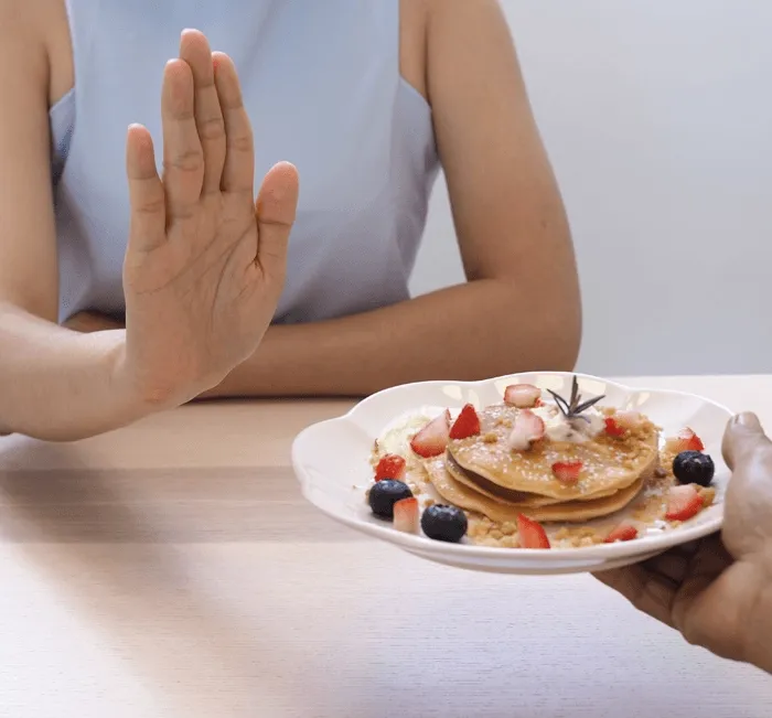 Woman resisting unhealthy food while trying to lose weight